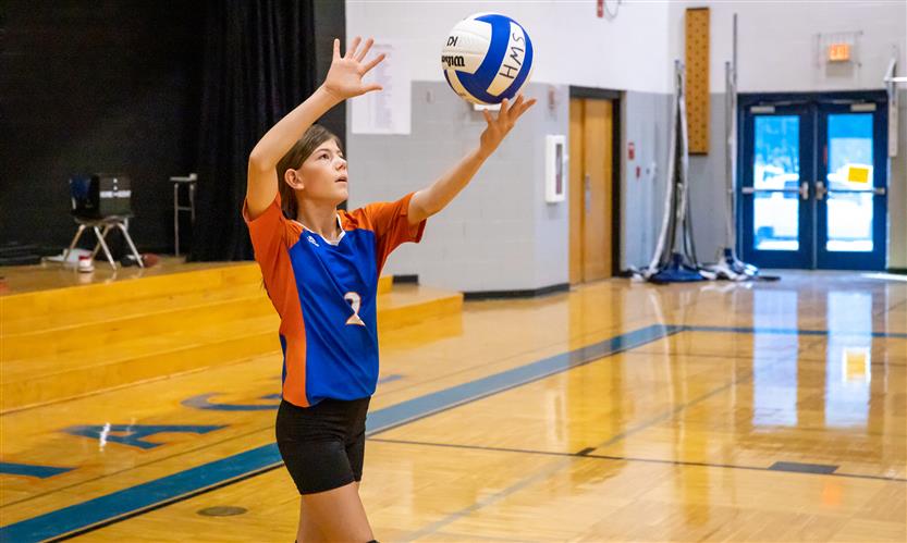 A volleyball player prepares to serve